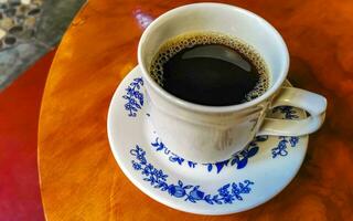 pot de tasse blanc bleu avec table basse en bois noir mexique. photo