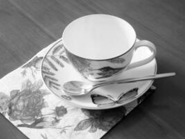 Tasse à café vide debout sur une table en bois pour un café savoureux et sombre photo