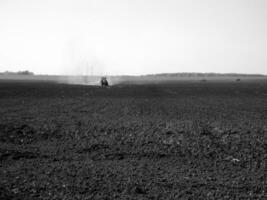 labouré champ par tracteur dans noir sol sur ouvert campagne la nature photo