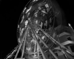 La grande roue ronde tourne vite dans la nuit noire photo