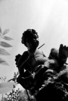 magnifique Cupidon ange statue avec ailes sur retour dans ancien jardin photo