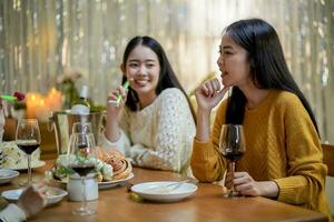 de bonne humeur copains profiter Accueil anniversaire vacances faire la fête. asiatique copains applaudissement en buvant rouge du vin célébrer Nouveau année faire la fête. photo