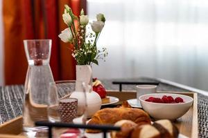 petit déjeuner au lit. framboises, café, gâteau, croissant. hôtel confortable. photo