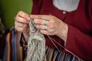 gros plan des mains d'une femme âgée tricotant. - image