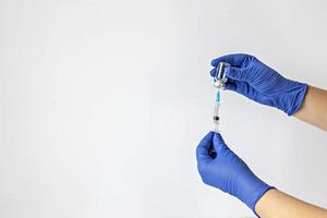 un travailleur médical en gants médicaux aspire une dose de vaccin contre le coronavirus dans une seringue. le concept de vaccination, immunisation, prévention des personnes de covid-19 photo