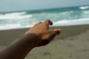 photo de personnes tendant la main gauche vers la mer
