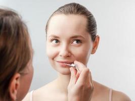 esthéticienne traite les lèvres, soin du visage photo