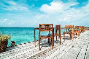 table et chaise en bois d'extérieur vides avec fond vue mer aux maldives photo