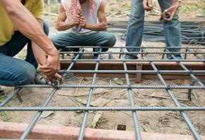 les travailleurs préparent des poteaux en acier pour la construction d'une maison photo