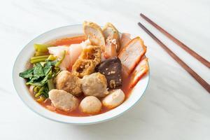 nouilles aux boulettes de viande dans une soupe rose ou yen ta quatre nouilles à l'asiatique photo