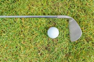 clubs de golf et balle de golf sur fond d'herbe verte photo