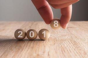 Mettre la main sur 2018 mot écrit en boule en bois photo