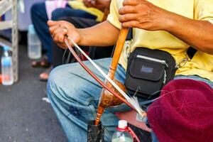 fermer mains de thaïlandais rue musicien en jouant thaïlandais violon à chiang mai en marchant rue. le thaïlandais violon est utilisé dans à cordes instruments comme le conducteur et est le base pour le référence mélodie. photo
