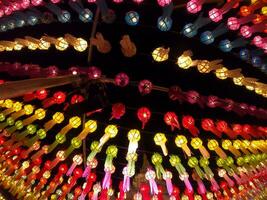 vue colorée vers le haut et vue de dessous des lanternes thaïlandaises de style lanna à accrocher devant le temple la nuit au festival loy kratong. photo