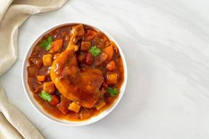 ragoût de poulet maison avec tomates, oignons, carottes et pommes de terre sur assiette photo