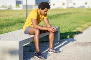 homme noir consultant son smartphone avec une application d'exercice