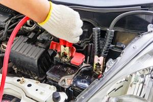 charge de la batterie de la voiture avec des câbles de démarrage électriques photo