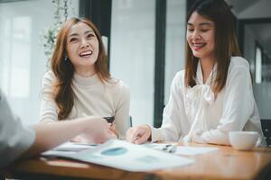 souriant diverse des employés collègues avoir amusement rire coopérer idée de génie sur ordinateur à Bureau équipe réunion. content Multi-éthnique hommes d'affaires travail ensemble sur portable discuter affaires des idées dans grouper. photo