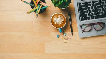 Haut voir, en bois Bureau bureau avec portable ordinateur, tasse de café, stylo et monocle, copie espace, moquer en haut. photo