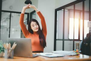 affaires femme relaxant avec mains derrière sa tête et séance sur un Bureau chaise photo