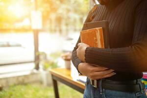 Jeune femme en portant loi livre dans sa main à la revue et comprendre loi avant prise examen à devenir avocat. concept de en train de lire livres à comprendre et apprendre loi avant prise examen à devenir avocat. photo