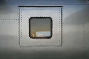 métal mur dans Contexte est mur de un avion fuselage cette a été réutilisé comme Résidentiel véhicule. métal mur avec métal rivets tenir les articulations ensemble est métal mur de un avion et copie espace photo