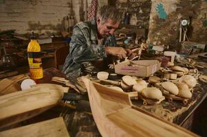 fabrication en bois jouets dans atelier, artisan dans action, vieux artiste à travail photo