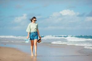 jeune femme heureuse marchant sur la plage photo