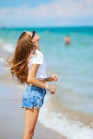 adorable adolescente sur la plage profite de ses vacances d'été photo