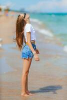 mignonne peu fille à plage pendant Caraïbes vacances éclabousser photo