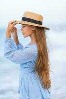 magnifique adolescent fille sur tropical rivage à le coucher du soleil. magnifique peu fille dans robe à plage ayant amusement. content fille prendre plaisir été vacances Contexte le bleu ciel et turquoise l'eau dans le mer photo