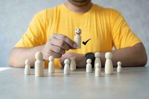 le Humain main cueillette en haut un sourire en bois la personne de groupe de beaucoup ordinaire en bois gens Les figures. photo