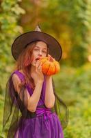 Jeune fille en costume d'halloween avec citrouille photo