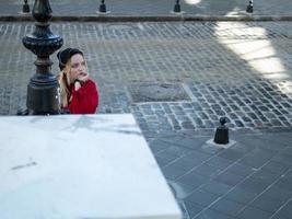 une jeune fille blonde dans un chapeau noir tricoté et une veste rouge photo