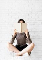 femme assise sur la chaise avec les jambes croisées en lisant un livre photo