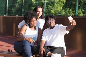 des filles heureuses de différentes nationalités prennent des selfies en été photo