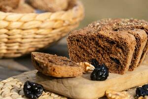 une pain de pain avec raisins secs et des noisettes sur une Coupe planche photo