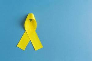 ruban jaune sur fond coloré. notion de cancer. photo