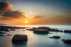 une magnifique le coucher du soleil plus de le océan avec rochers et l'eau. généré par ai photo