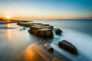 une longue exposition photographier de rochers sur le plage à le coucher du soleil. généré par ai photo
