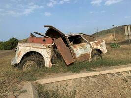 cassé et rouillé voiture a été garé dans un vide lot pour une longue temps donc il a été trop développé avec herbe photo