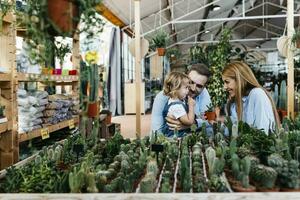 mère, père et fille dans le cactus zone à l'intérieur une jardin centre photo