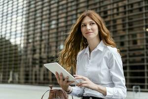 Jeune femme d'affaires dans le ville, en utilisant numérique tablette photo