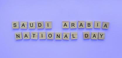 septembre 23, saoudien Saoudite nationale jour, une minimaliste bannière avec le une inscription dans en bois des lettres sur une bleu Contexte photo