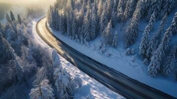 aérien vue de courbée venteux route dans neige couvert forêt. génératif ai photo