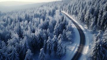 aérien vue de courbée venteux route dans neige couvert forêt. génératif ai photo