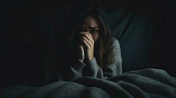 déprimé femme séance tête dans mains sur le lit dans le foncé chambre à coucher, solitaire et malheureux concept. génératif ai photo