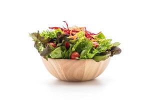 salade mixte dans un bol en bois sur fond blanc photo