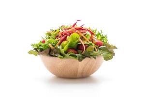 salade mixte dans un bol en bois sur fond blanc photo