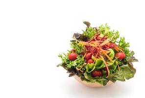 salade mixte dans un bol en bois sur fond blanc photo